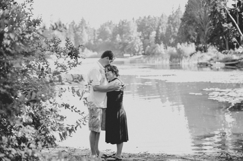 Bride and groom hugging near the water at Island Lake Park in Kitsap County. 