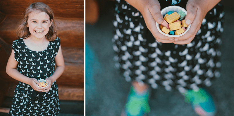 Little girl holding fun, colorful lego-shaped candy. 