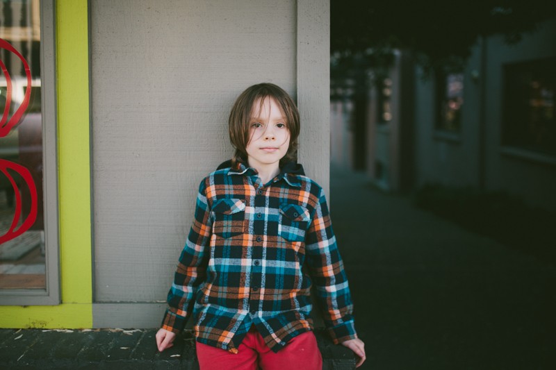 Lifestyle portrait of a boy in colorful clothing with messy hair. 