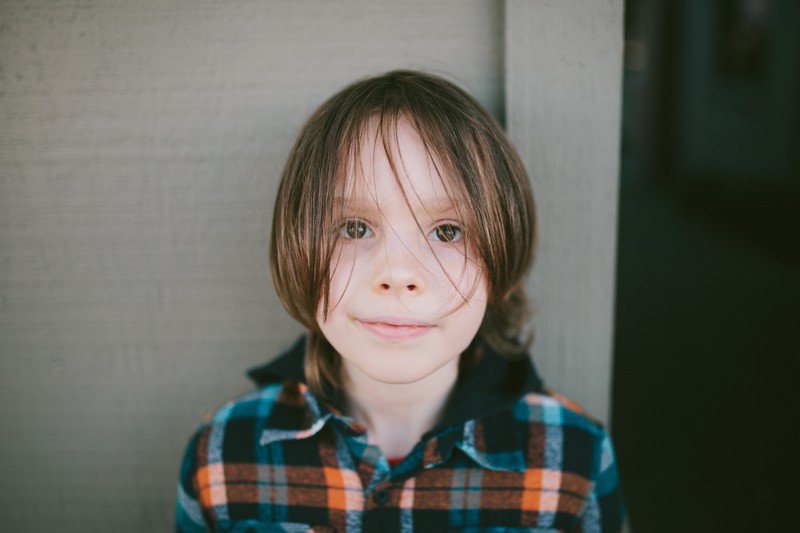 Lifestyle portrait of a boy with long messy hair. 