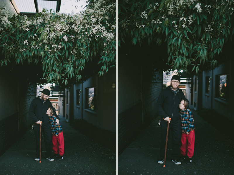 Father and son portrait under lush flowers and greenery. 
