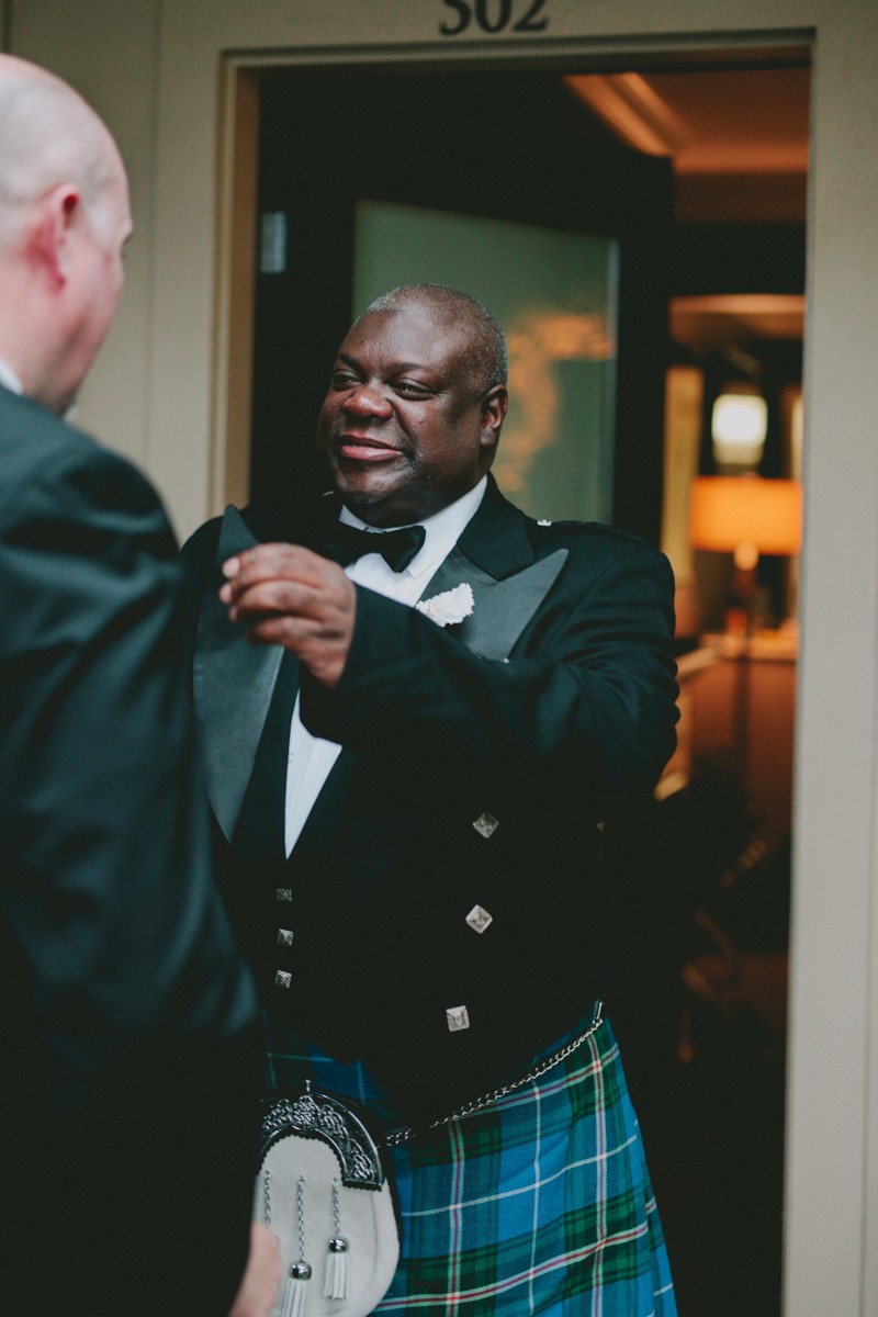 Groom fixes his fiance's suit during their first look. 