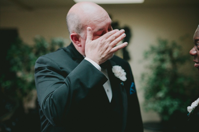 Groom wipes tears from his face after seeing his fiance before their wedding. 