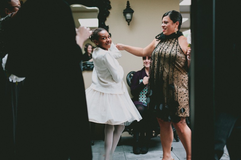 Groom's niece twirls in a white dress and sweater. 