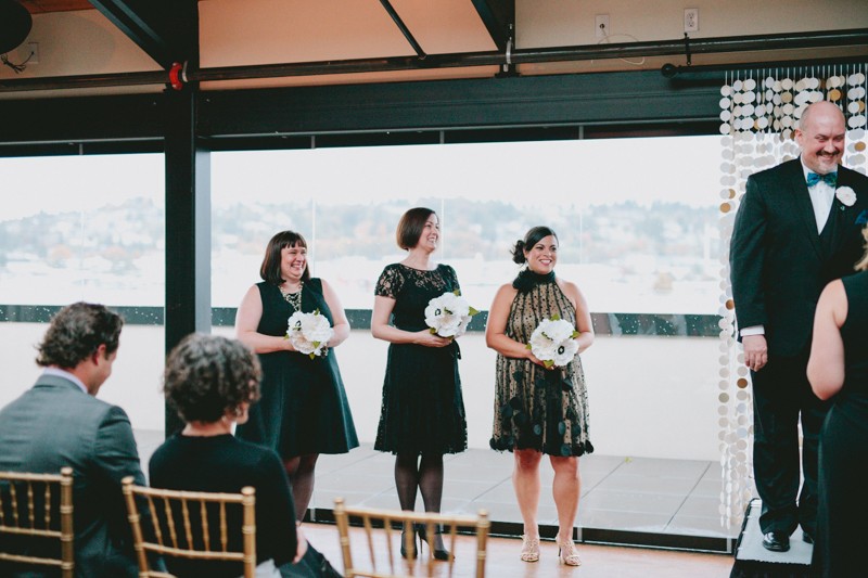 Groomsmaids holding paper bouquets at a same sex wedding. 