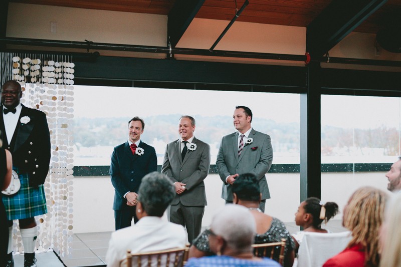 Groomsmen in suits with paper flower boutonnieres. 