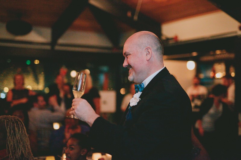 Groom with a glass of champagne at wedding reception. 