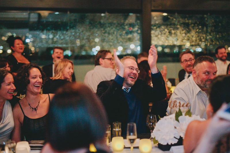 Guests laugh and clap at Seattle wedding reception. 