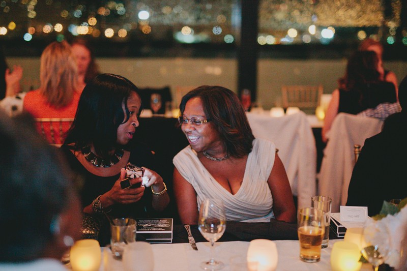 Guests look at phone during an evening reception. 