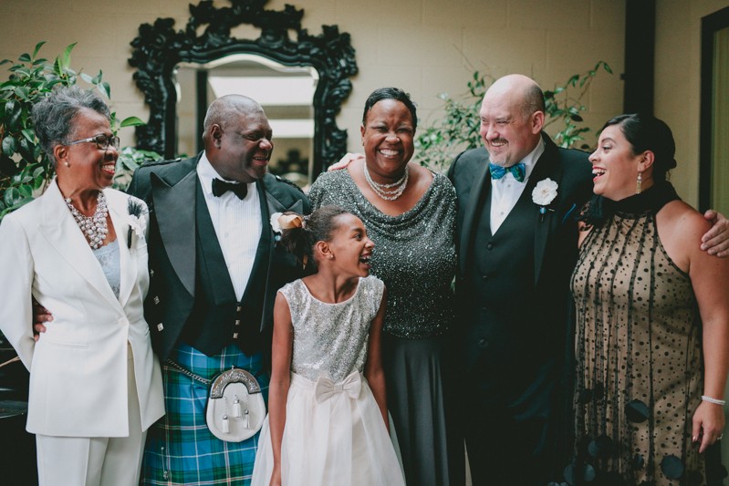 Two grooms laughing with their families. 