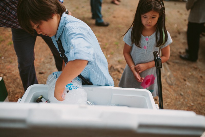Kids putting ice in a cooler at the park.
