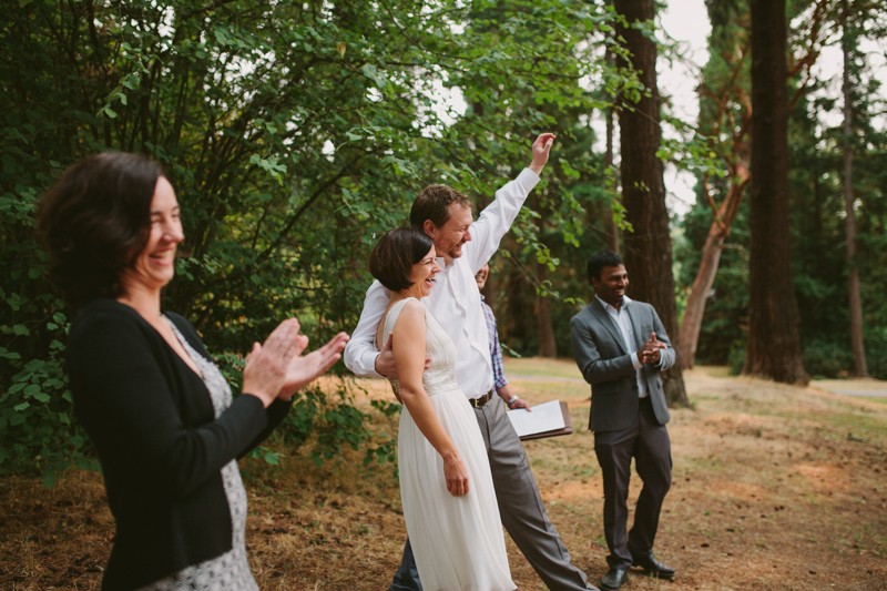 Wedding party laughing after ceremony at Lincoln Park in Seattle. 