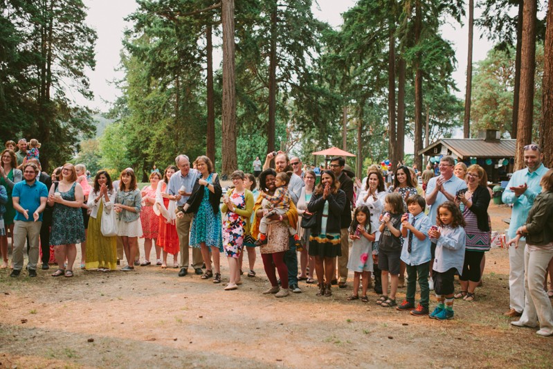 Wedding guests at a Seattle park, clapping for bride and groom.