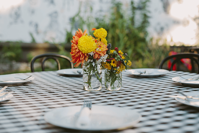 Vibrant garden centerpieces on a table with a checkered table cloth. 