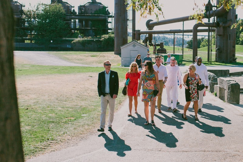 Brightly dressed wedding guests gather for a wedding at Gas Works Park in Seattle, Washington. 