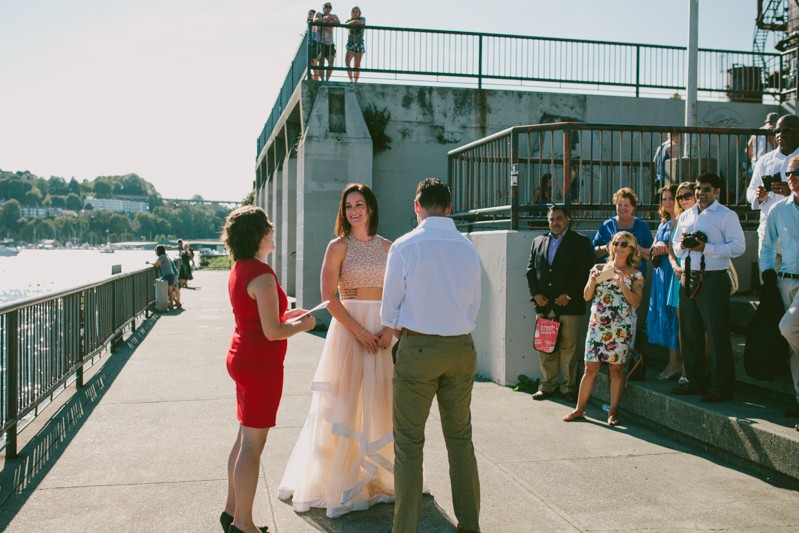 Guests and park goers watch non-traditional wedding ceremony at Gas Works Park. 