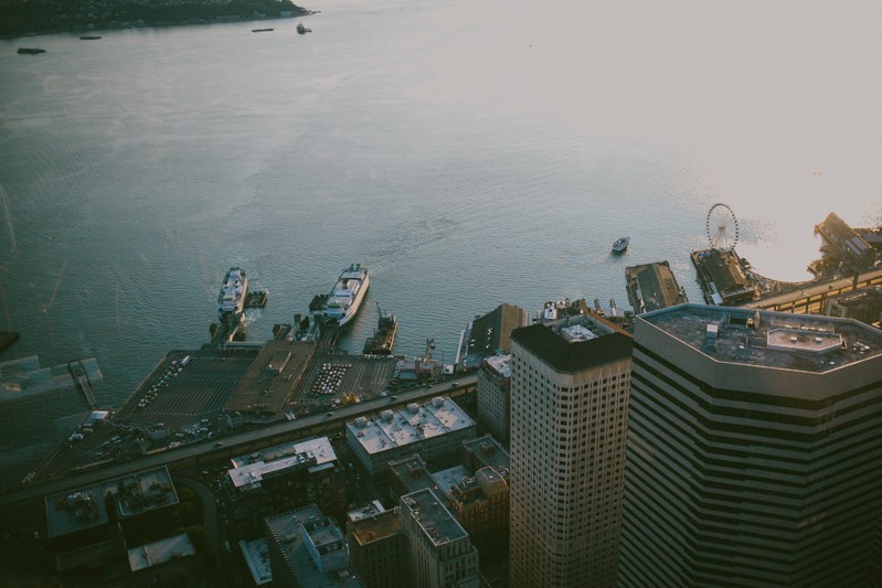 Elopement photographer, with a view of Downtown Seattle, with ferry boats and the Great Wheel. 