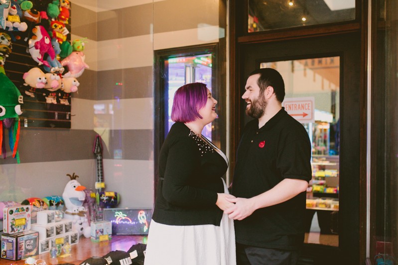 Arcade themed engagement session in downtown Bremerton, with bride and groom smiling at each other. 