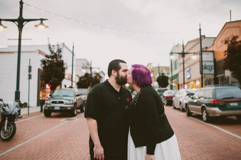 Engaged couple kissing in the middle of a street in downtown Bremerton, WA. 
