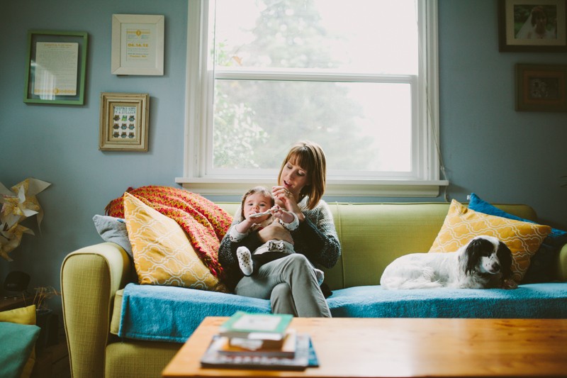 A mom and baby cuddle on a vibrant modern couch in Bainbridge Island, WA. 