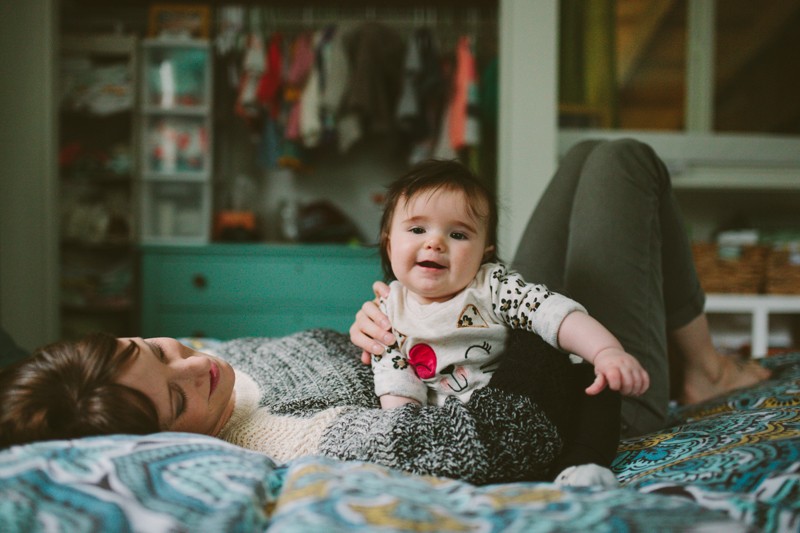 Adorable smiling baby girl sitting with her mom. 