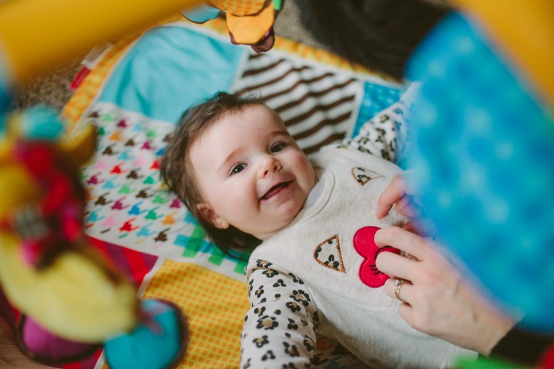 Kitsap County lifestyle baby photographer, with baby on a colorful play mat. 