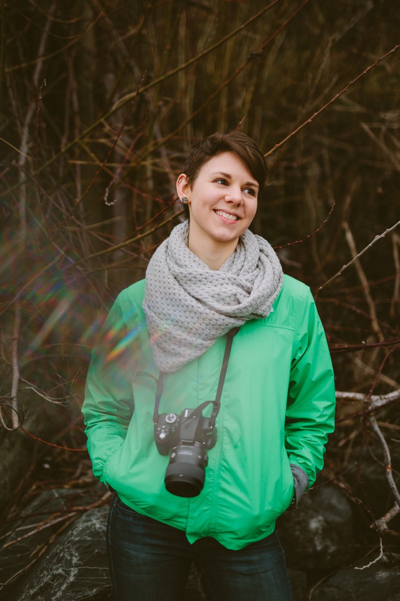 Indianola woman in a green raincoat, grey scarf, and a short hairstyle. 