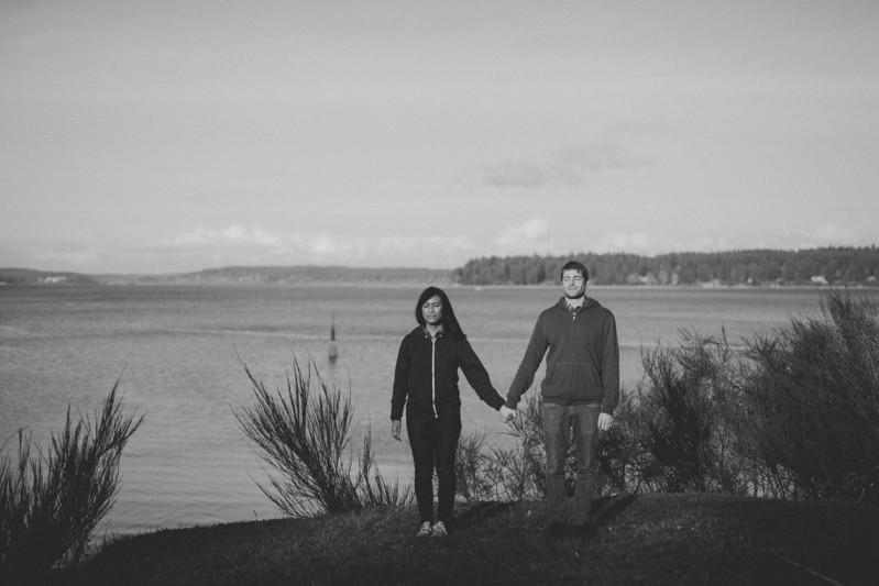 Adventurous portrait session in Bremerton, with a cute couple holding hands, near the water. 