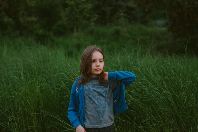 Bainbridge Island portrait session at twilight, with boy standing in long grass. 