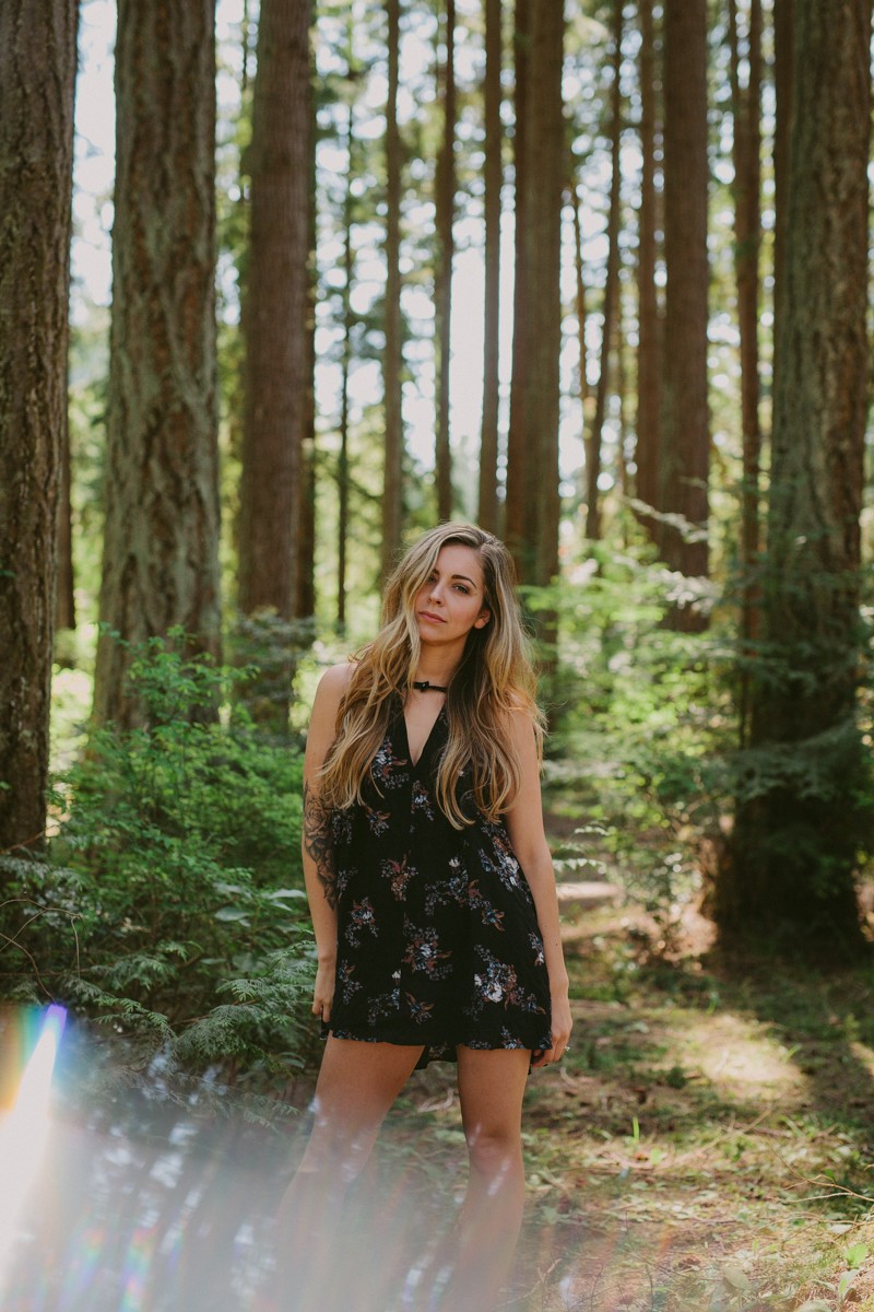 Model wearing a Free People dress at Kitsap Memorial State Park, with tall trees on a summer day. 