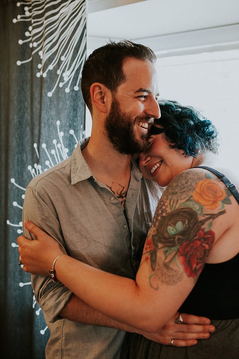 Adorable tattooed couple cuddling in their home, in Bremerton, WA. 