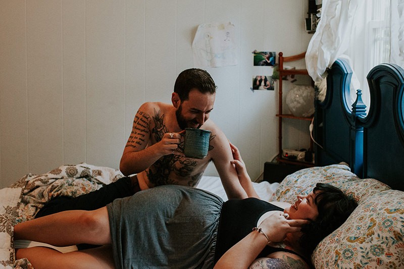 Cute couples session, in home, with man sipping coffee. 
