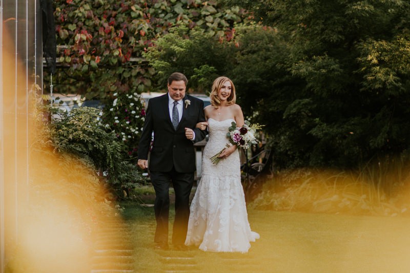 Bride's father walks her down the aisle at Black Diamond Gardens. 