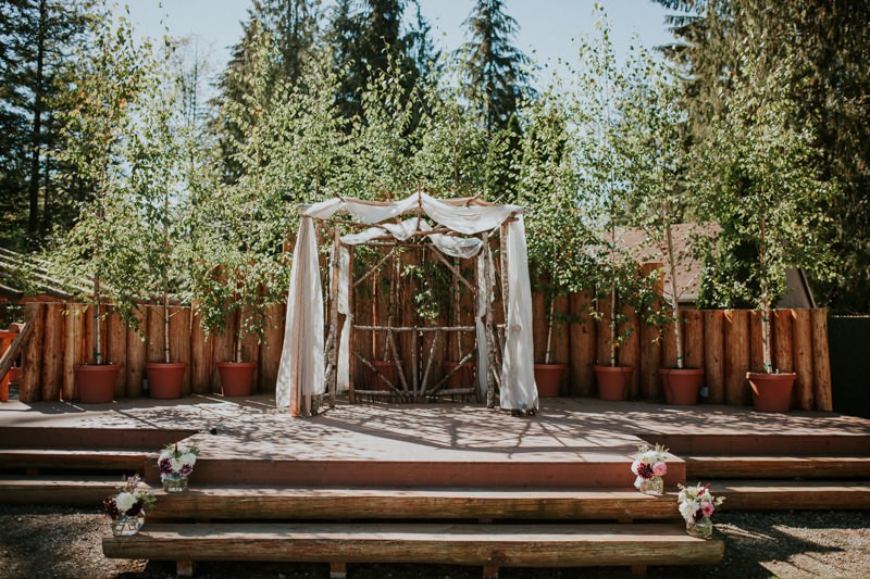 Lovely rustic garden wedding altar, with wooden arbor draped in fabric, at Black Diamond Gardens. 