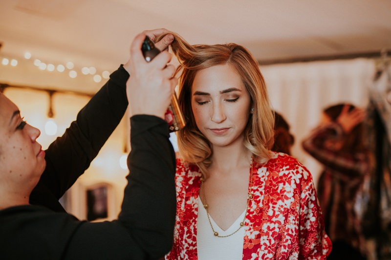 Modern bride with shoulder-length hair getting ready, wearing a colorful floral silk robe.