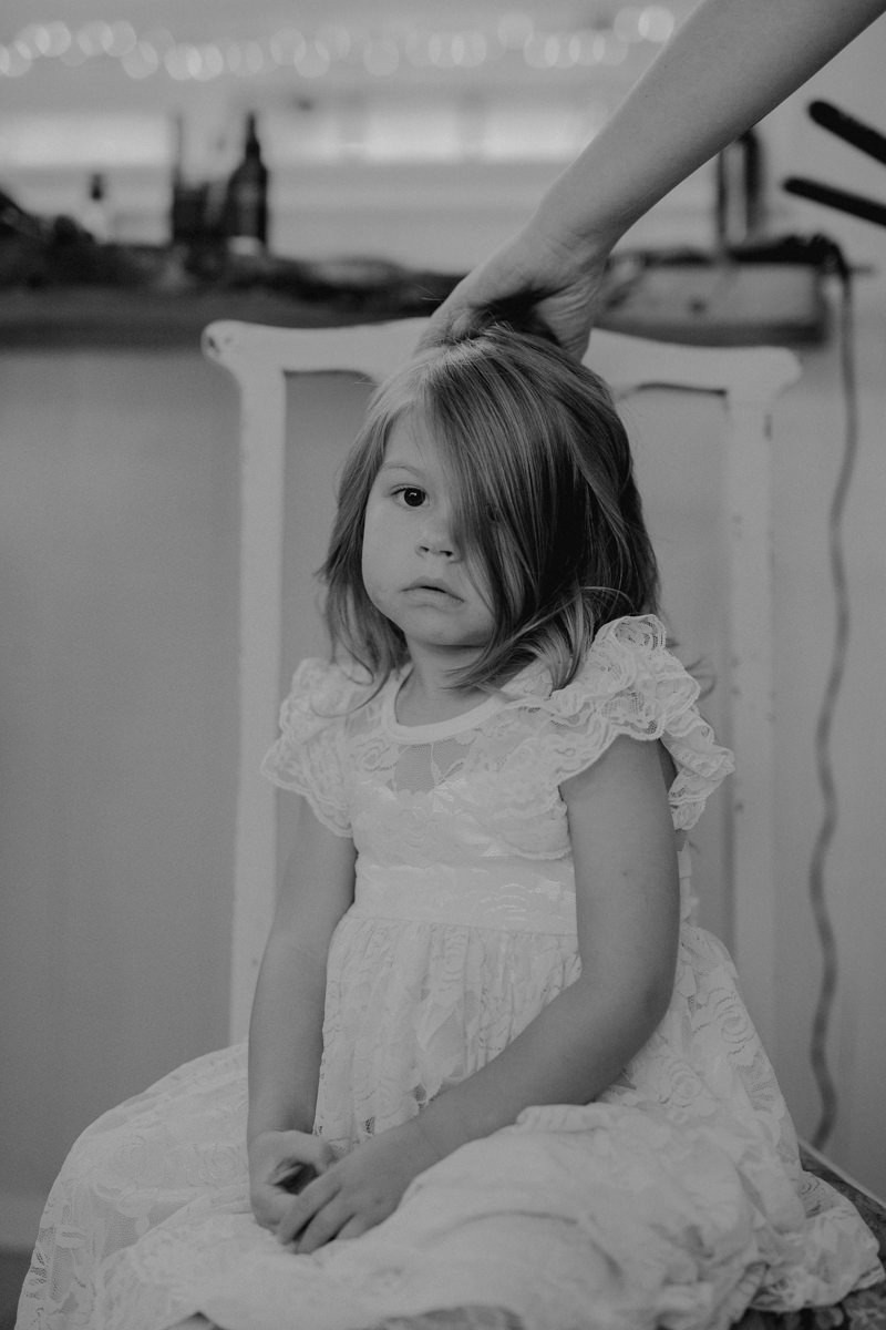 Darling flower girl getting hair done for a wedding. 