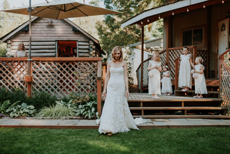 Bride in a strapless beaded gown with adorable flower girls in lace cap sleeve dresses. 