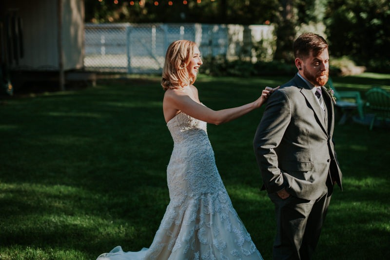 Modern bride and groom first look, with bride in a strapless dress and groom in a grey suit. 