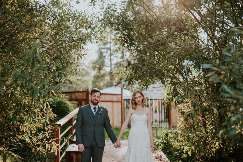 Badass bride and groom, holding hands on a dock at Black Diamond Gardens in Washington. 