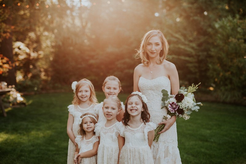 Garden bride and flower girls, with bride in a strapless dress, and girls vintage-inspired lace dresses. 