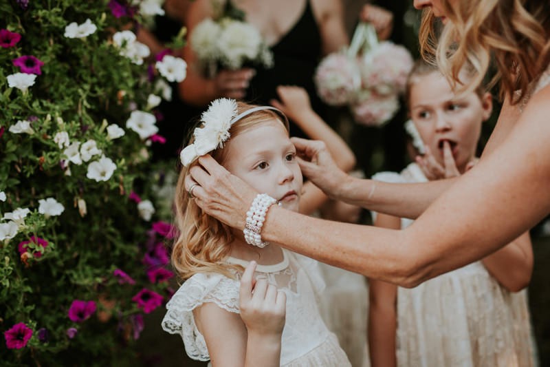 Grandmother fixes flower girl's headband before ceremony. 