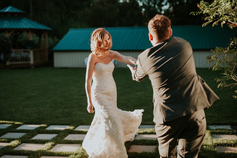 Bride in a strapless beaded dress dances away from the altar, with groom in a grey suit, in Black Diamond, WA. 