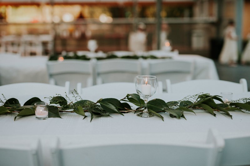 Simple greenery garland reception decor, with seeded Eucalyptus and white candles. 