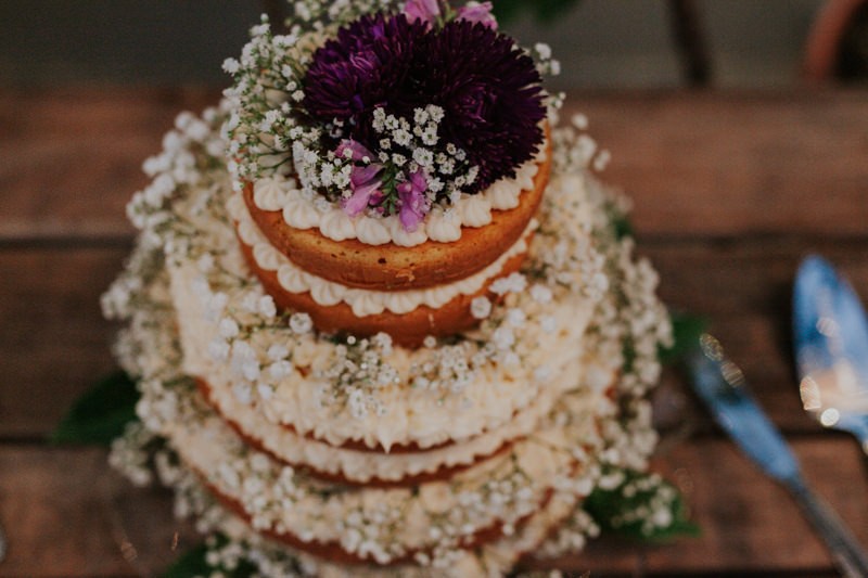 Simple wedding cake topped with purple Dahlias and Baby's Breath. 