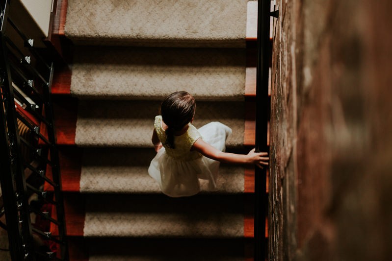 Flower girl walking up stairs at home. 