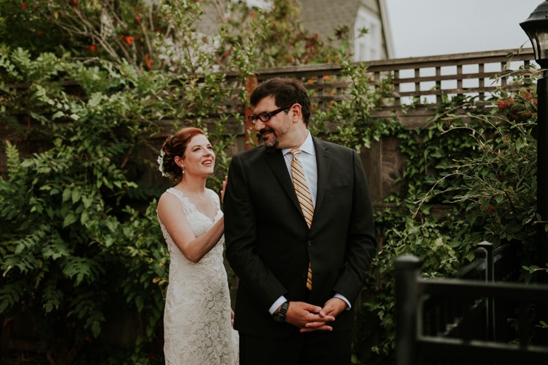 First look with bride in a sweetheart neckline gown, and groom in a black suit with a yellow tie. 