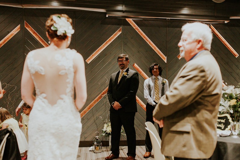 Groom smiles as he sees his bride during the processional. 