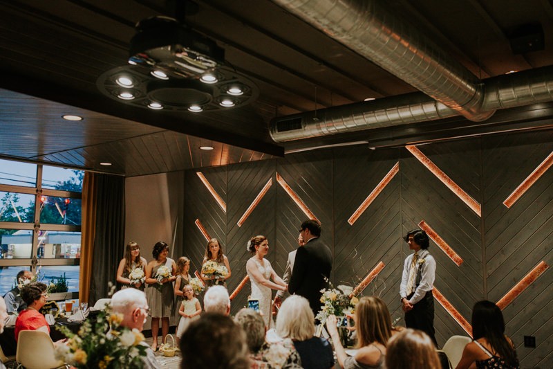 Modern indoor wedding ceremony with a variety of lighting. 