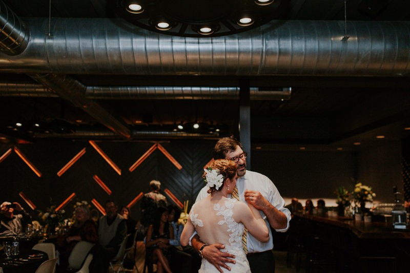 Sweet first dance moment, with bride in a gorgeous illusion-back dress. 