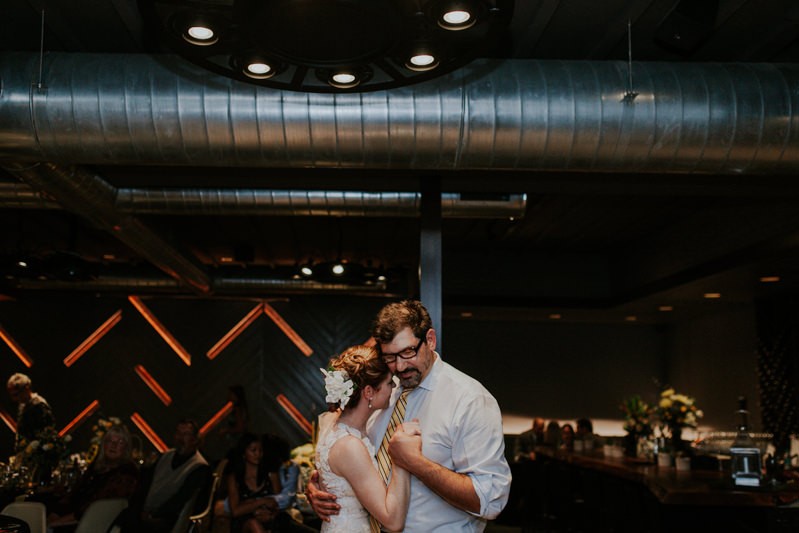 Romantic first dance, with bride and groom holding hands, at The Pine Room. 